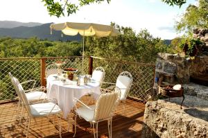 a table and chairs on a deck with a fireplace at Villa Fümehan Tarihi Rum Taş Ev Since 1820 in Kayakoy