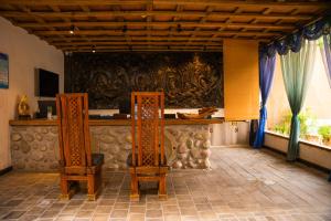 two chairs sitting in front of a bar in a room at 唐韵驿馆 in Dunhuang