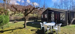 a table and chairs in front of a tiny house at LES CHALETS de MONTORGUEIL in Saurat