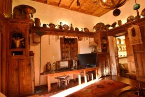 a room with a wooden table with a television andcellaneous items at Villa Fümehan Tarihi Rum Taş Ev Since 1820 in Kayakoy