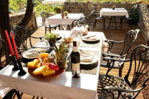 a table with a bottle of wine and a plate of fruit at Villa Fümehan Tarihi Rum Taş Ev Since 1820 in Kayakoy