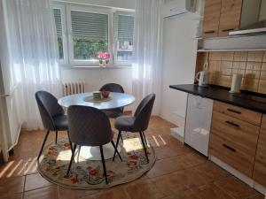 a kitchen with a table and chairs in a kitchen at Apartman Milica 1 in Doboj