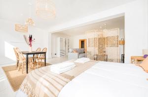a white bedroom with a large bed and a table at Grand Rue Studio - sleeps 5 in Luxembourg
