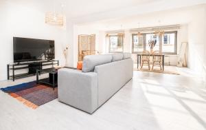 a white living room with a couch and a piano at Grand Rue Studio - sleeps 5 in Luxembourg