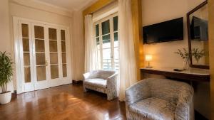 a living room with a chair and a tv and a couch at Cairo Dream Boutique Hotel in Cairo