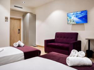 a hotel room with two beds and a chair at The Wood Hotel & Spa near Magic City in Tashkent +50 photos