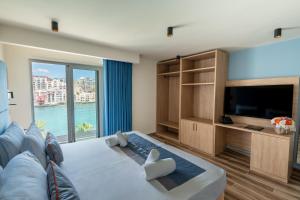 a living room with a large bed and a tv at C'est La Vie Hotel Marsascala in Marsaskala