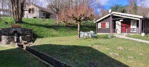 a small cabin in a yard with a tree at LES CHALETS de MONTORGUEIL in Saurat
