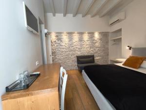 a bedroom with a bed and a desk with a television at La Maison in Trani