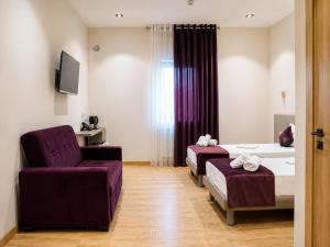 a hotel room with two beds and a purple chair at The Wood Hotel & Spa near Magic City in Tashkent
