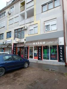 Ein blauer Wagen parkte vor einem Gebäude in der Unterkunft Studio centar Lazic 2 in Šid
