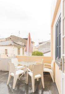a patio with a table and chairs and a umbrella at PISO CON TERRAZA in Ribadeo