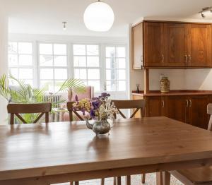 a kitchen with a wooden table with a vase of flowers on it at PISO CON TERRAZA in Ribadeo +31 photos