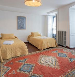 a bedroom with two beds and a rug at PISO CON TERRAZA in Ribadeo