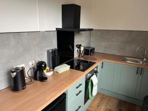 a kitchen with a wooden counter top with a sink at Beamish Lodge in Stanley