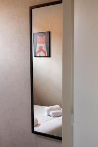 a mirror on a wall with a bed and a picture at Het Bakkershuus in Gramsbergen +38 photos