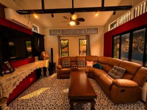 a living room with a couch and a table at Baannaisuk Pool Villa in Ban Mae Pu Kha