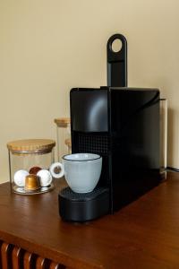 a coffee maker with a bowl on a wooden table at Het Bakkershuus in Gramsbergen