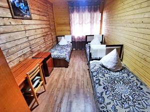 a room with two beds and a desk in a cabin at Artuch Camp - Fan Mountains in Yakkakhona