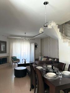 a living room with a table and a living room with a couch at Armonia Maisonette in Pefkochori