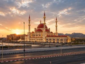 a building with two domes and a mosque with the sunset at سويت tolan in Hail