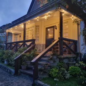 a house with a wooden staircase leading to the front door at Whyte Pyne Transient House in Baguio