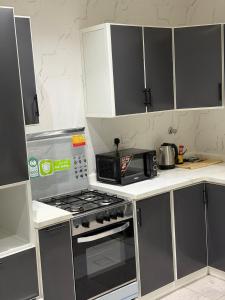 a kitchen with a stove and a microwave at Home apartment 2 in Medina