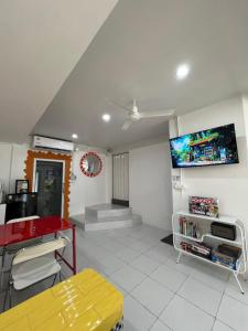 a room with a red table and a tv on the wall at One life Hostel in Chiang Mai +9 photos