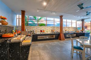 a large kitchen with tables and chairs and windows at Resort Terra Paraiso Goa - A Beach Property in Calangute