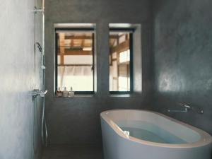 a bath tub in a bathroom with a window at 安宅ノ宿 沖 in Komatsu +105 photos