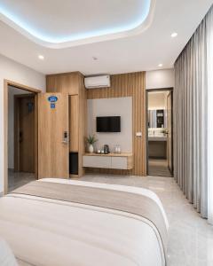 a bedroom with a large bed and a television at Hotel Bình Hải in Trương Tần