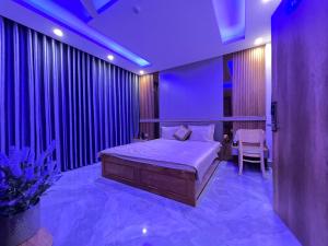 a bedroom with a bed and purple lighting at Hotel Bình Hải in Trương Tần