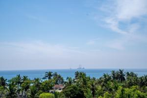 a view of the ocean from a resort with palm trees at RR complex in Trincomalee
