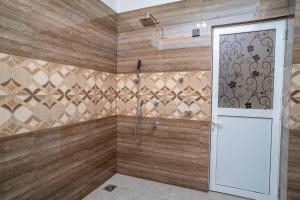 a bathroom with a shower with wooden walls at RR complex in Trincomalee +6 photos