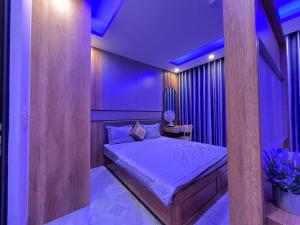 a bedroom with a bed with purple lighting at Hotel Bình Hải in Trương Tần