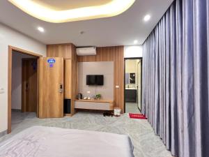 a hotel room with a bed and a television at Hotel Bình Hải in Trương Tần +1 photo