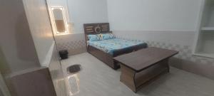 a small room with a bed and a table at Hotel KANHA in Karauli