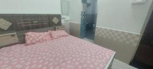 a bedroom with a bed with a pink comforter at Hotel KANHA in Karauli
