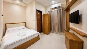 a bedroom with a bed and a flat screen tv at Hotel Grand Darbar in Barisāl