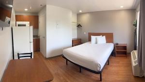 a bedroom with a bed and a table and a kitchen at Studio 6 Rancho Cordova, CA in Rancho Cordova