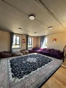 a living room with a couch and a large rug at Hostel 78 in Karakol