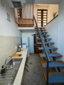 a kitchen with a sink and a spiral staircase at Sleep&Go Airport Transit Rooms Cluj-Napoca in Cluj-Napoca
