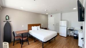 a bedroom with a bed and a table and a kitchen at Studio 6 Rancho Cordova, CA in Rancho Cordova