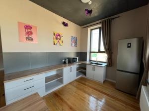 a kitchen with white cabinets and a counter top at Hostel 78 in Karakol