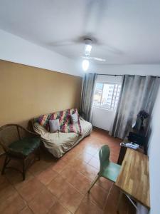 a living room with a couch and a table at Apartamento no centro, com garagem e wi-fi in Peruíbe