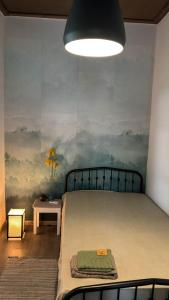 a bedroom with a bed with a painting on the wall at Guesthouse Story in Lagodekhi in Lagodekhi