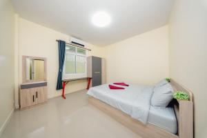 a small bedroom with a bed and a window at Nan's 2 Bedroom House in Krabi
