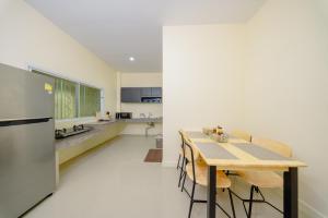 a kitchen and dining room with a table and a refrigerator at Nan's 2 Bedroom House in Krabi