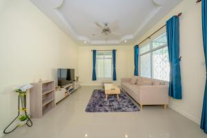 a living room with a couch and a tv at Nan's 2 Bedroom House in Krabi
