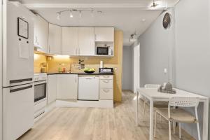 a kitchen with white appliances and a table and chairs at Home and Away in Vaksdal
